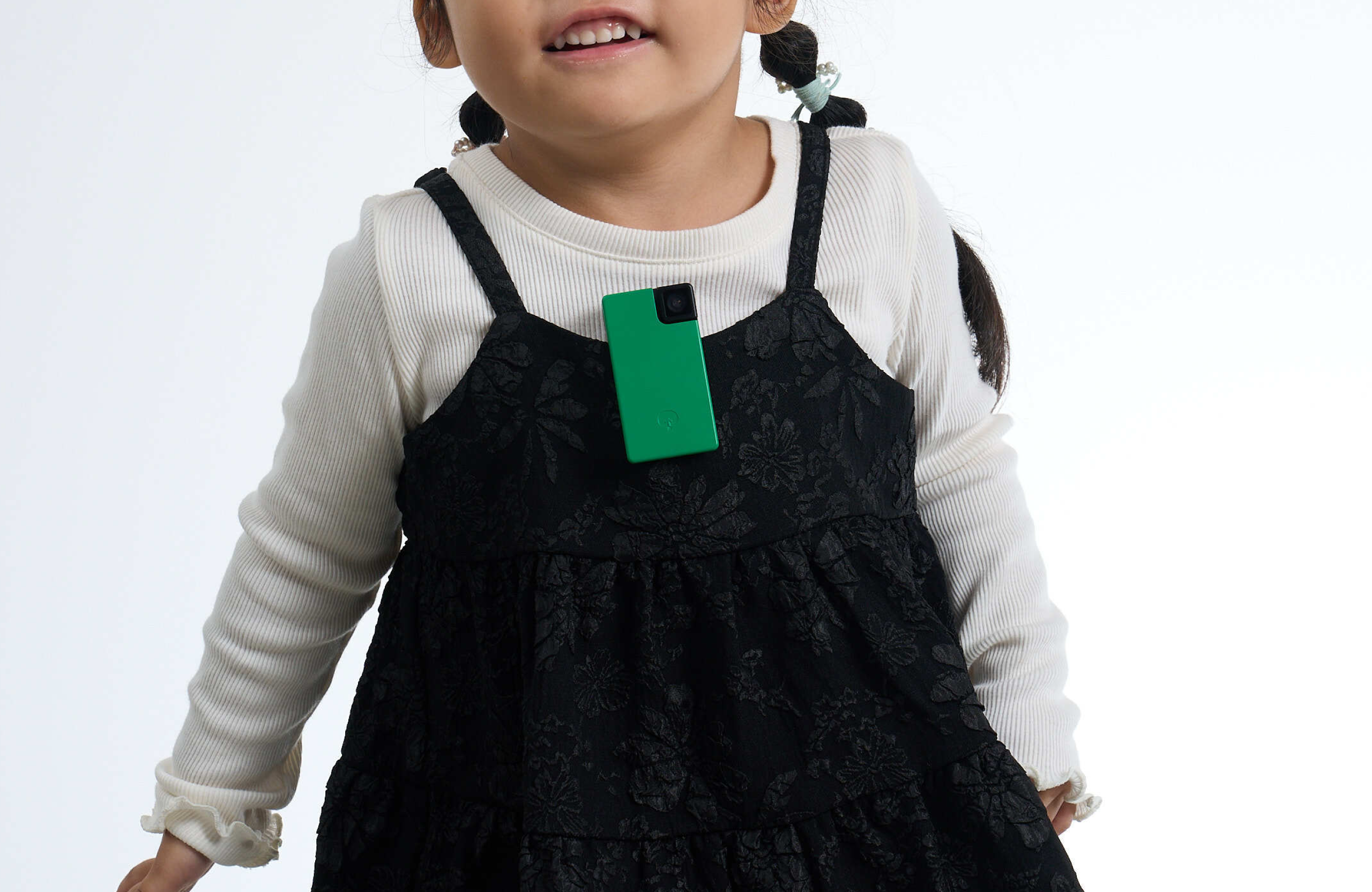 Child wearing a black dress with a green Saveclip